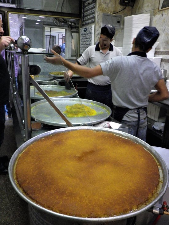 Heerlijke traditionele knafeh met gesmolten kaas, goudbruine kataifi en pistachenoten, geserveerd bij Habibah Sweets in Amman